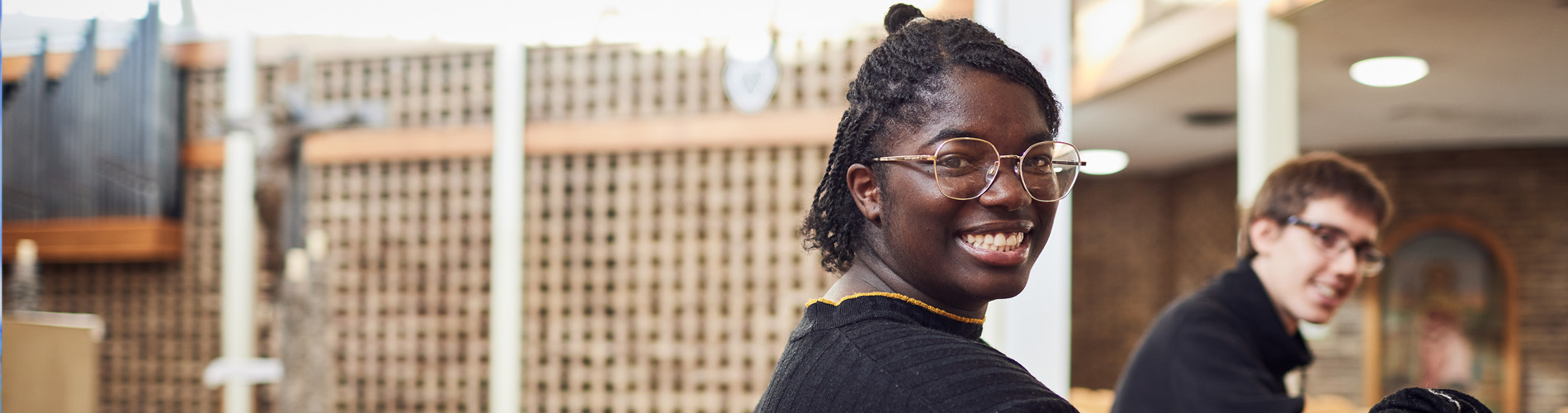 Student smiling in Leeds Trinity University chapel.