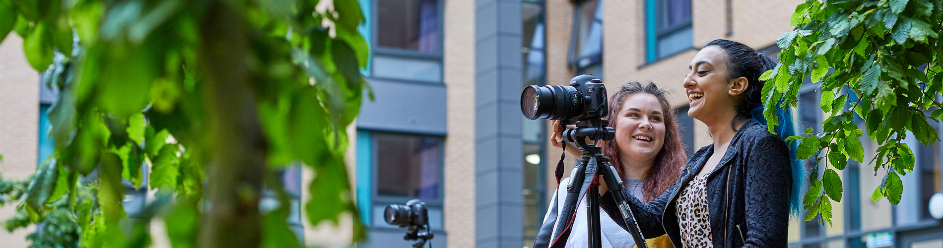 Students setting up a DSLR camera outside.