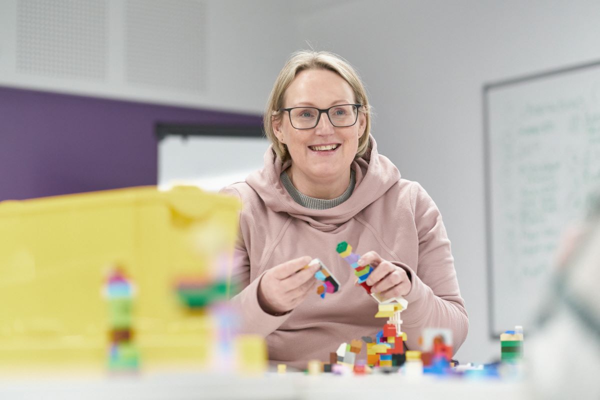 Female student playing with lego in CYPF lesson.