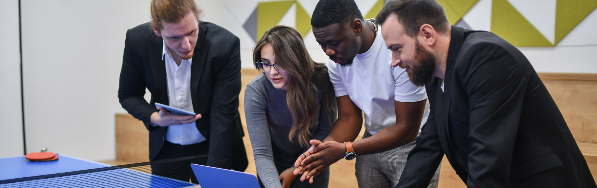 Students looking around laptop.