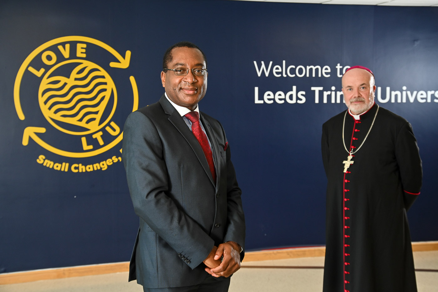 Professor Charles Egbu stood in the Leeds Trinity Atrium with The Right Reverend Marcus Stock, Bishop of Leeds.