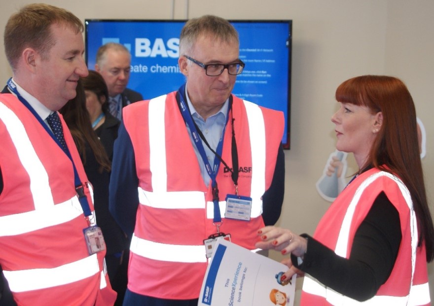 Colleagues in pink hi-vis jackets having a discussion..