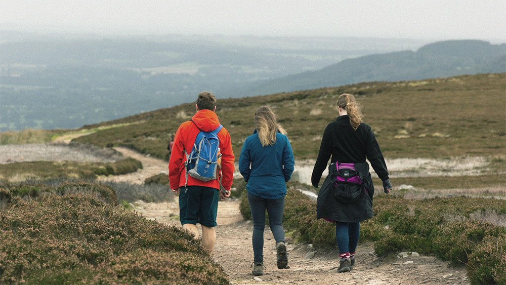 Three people walking on a moor..