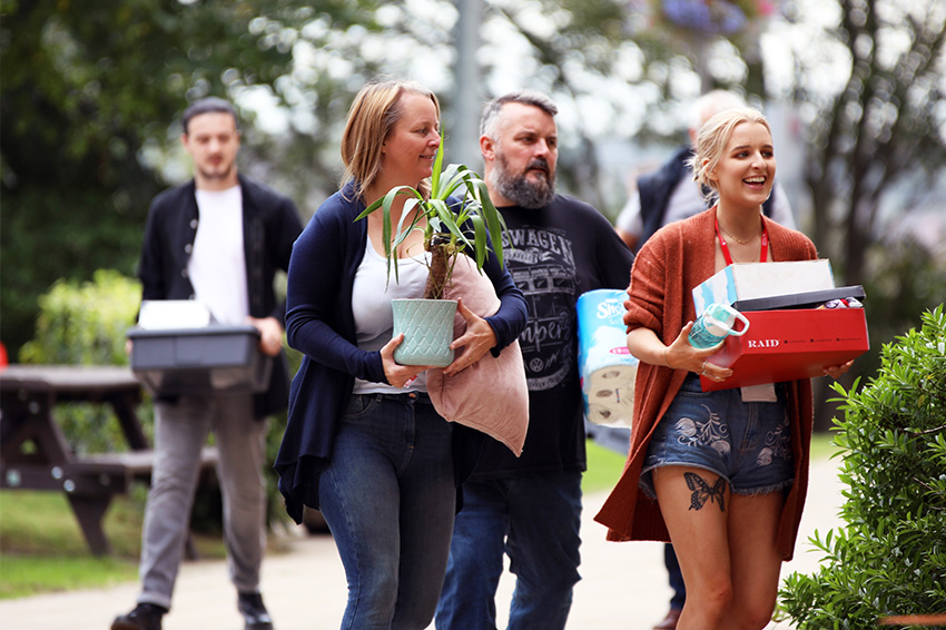 Parents help a student move into her halls on campus.