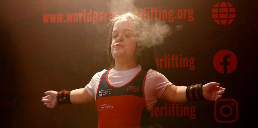 Female athlete in Team GB outfit with chalk.