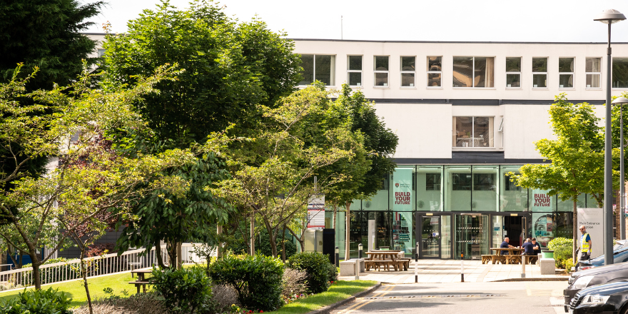 Front of Leeds Trinity building with trees to the left.