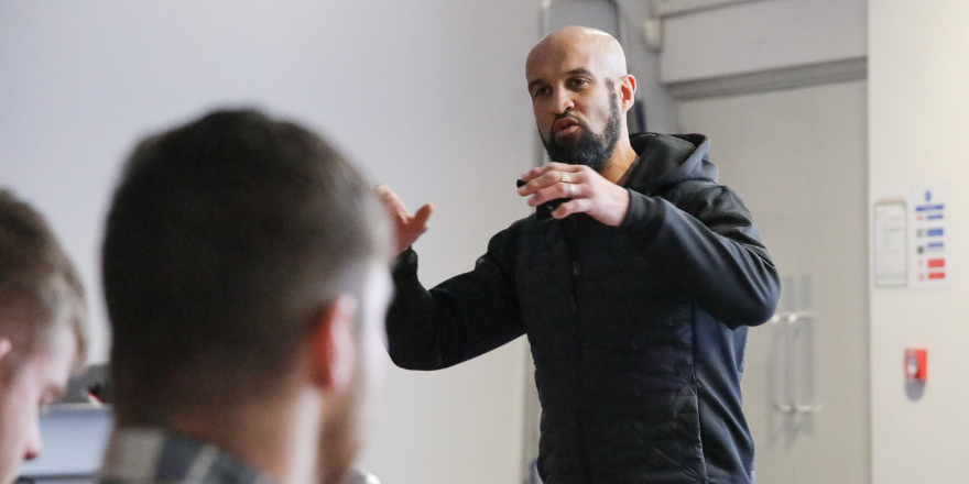 Male delivers talk to students.