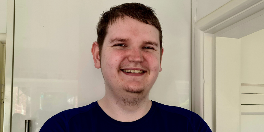 Male with short dark hair smiles for camera.