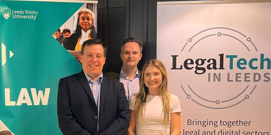 three people, one woman and two men, smiling celebrating law partnership to help others.