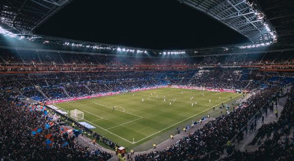 Image of a lit up football stadium from a distance.