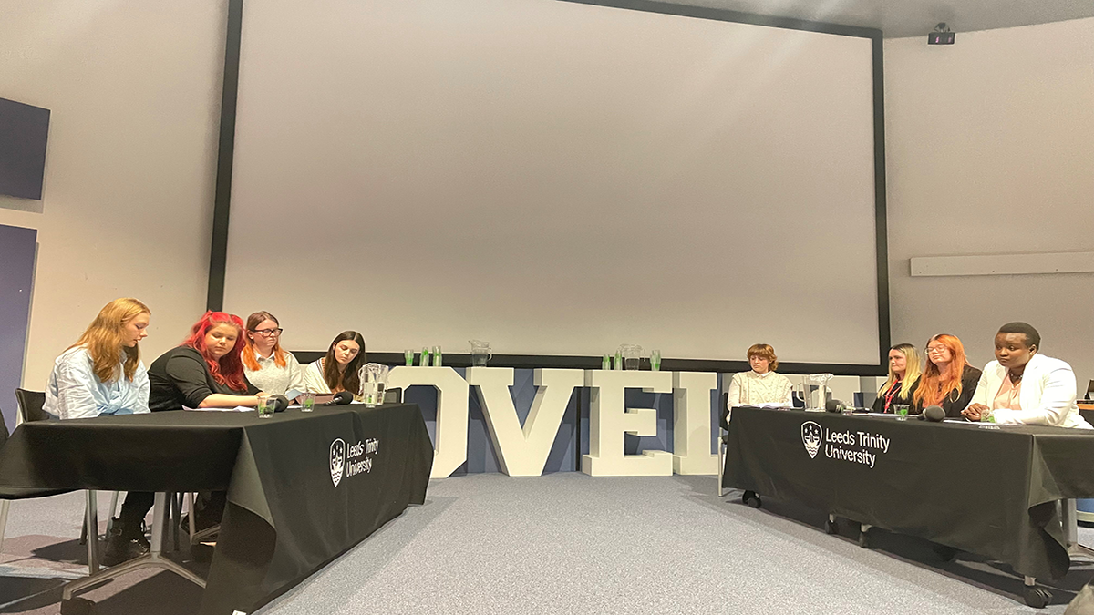 Students sitting across from each other at a Primary Education debate at Leeds Trinity University..