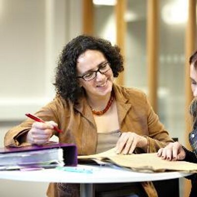 Professor Karen Sayer writing at a desk.