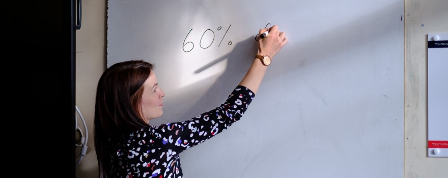 Teacher writing on whiteboard.