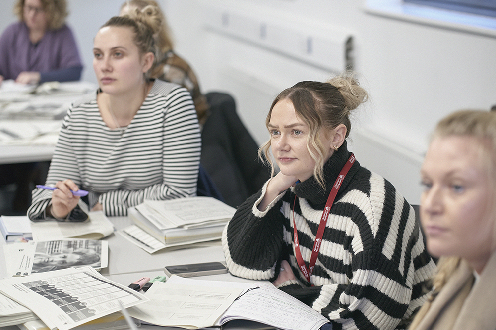 Three postgraduate students listening in a seminar.