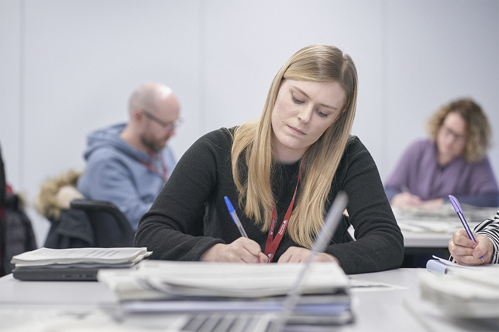 Postgraduate student making notes in a seminar.