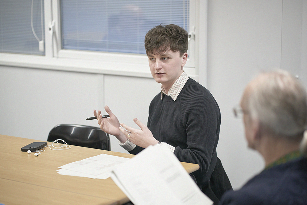 Postgraduate student engaged in discussion in classroom setting.