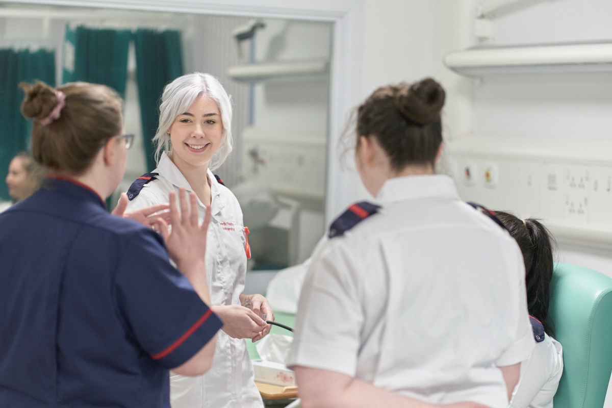 Two nursing students talking with their lecturer..