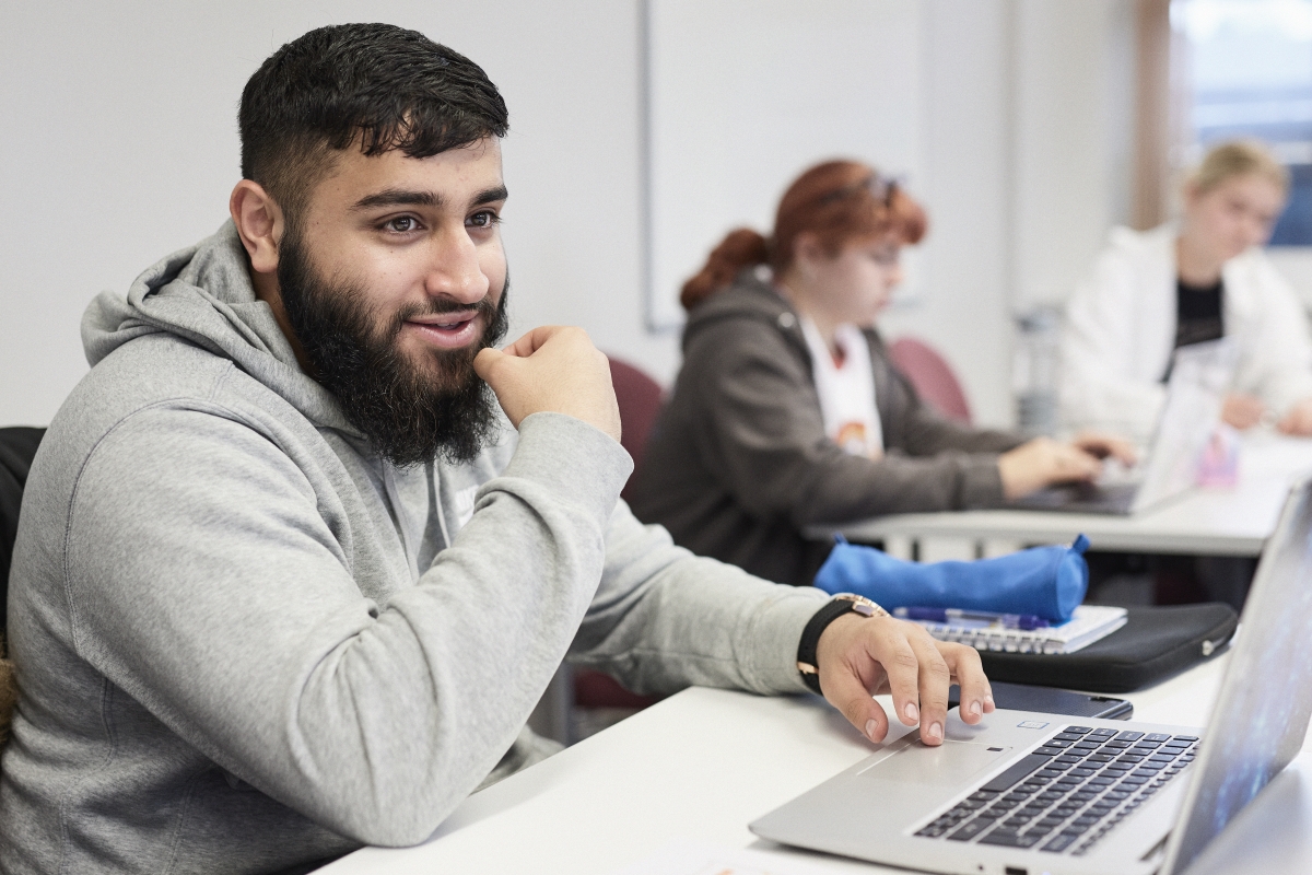 Student using laptop in classroom..