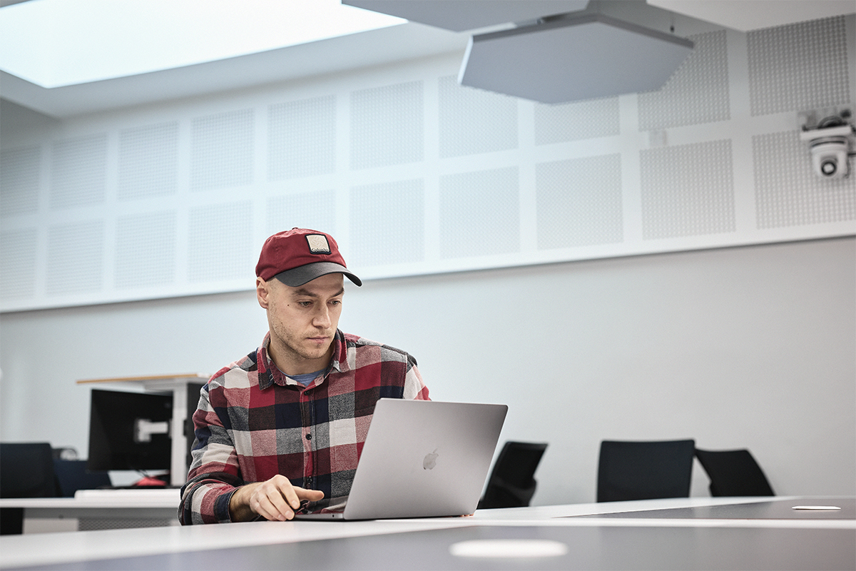 Student working on laptop in classroom.