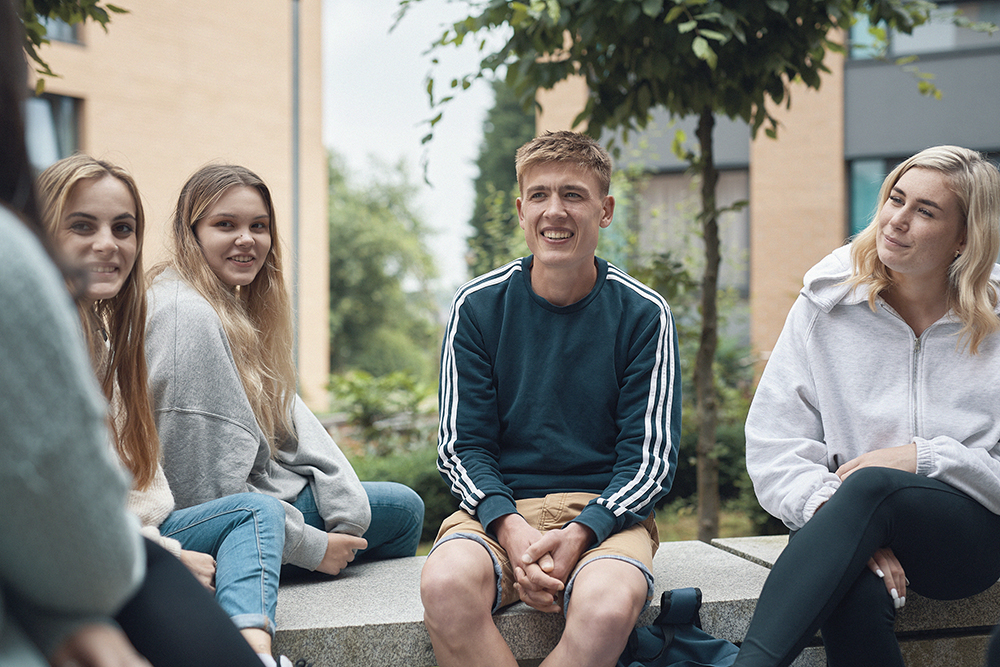 Students sitting in a group outside on Main Campus.