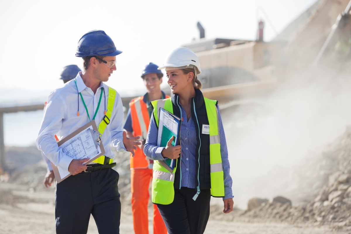 Two construction workers talking on a work site..