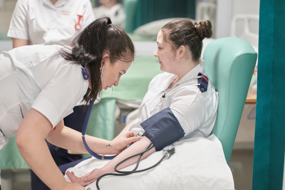 Nursing student giving a blood pressure test.