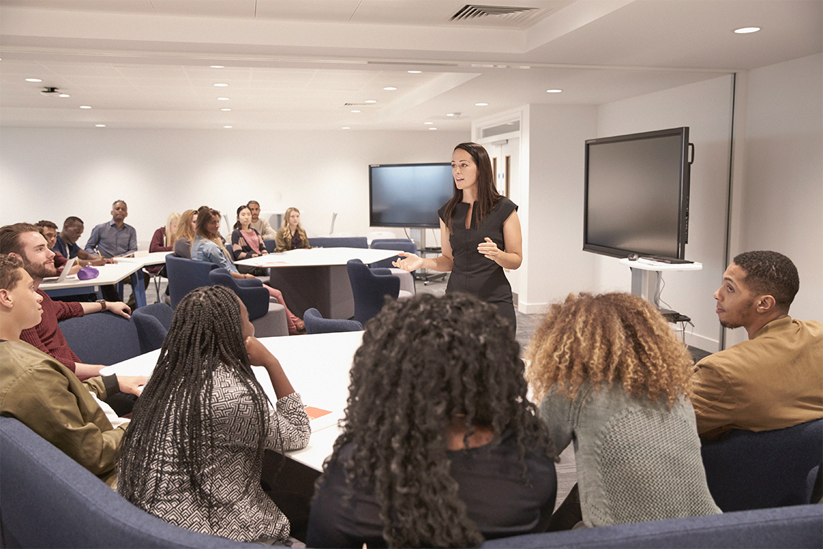 Presenter talking to crowd in a classroom.