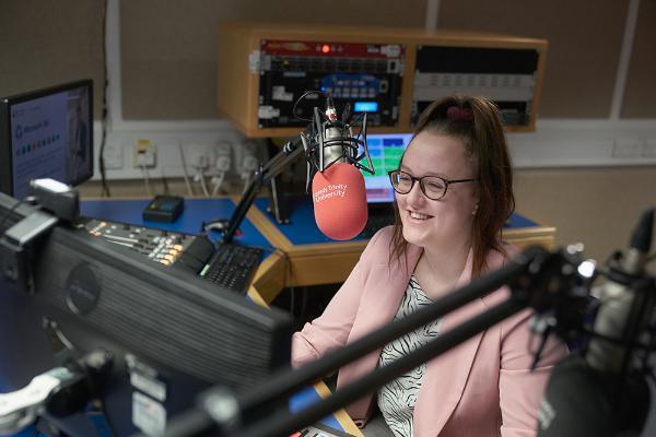 Journalism student records in the radio studio.